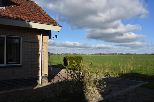 a house with a view of a large field at Vakantiehuis Weids uitzicht nabij Tjeukemeer in Rohel