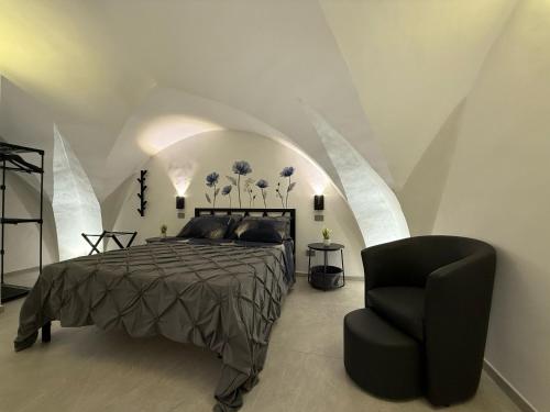 Un dormitorio con una cama y una silla negra. en Thangima, en Gallipoli