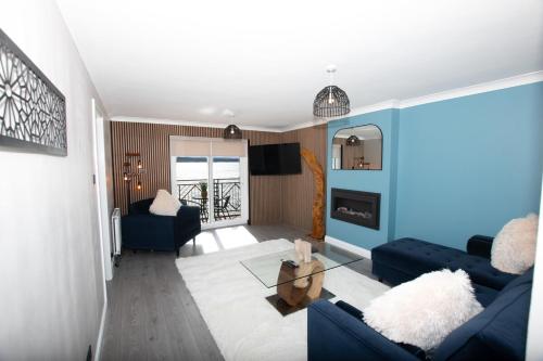 a living room with two blue couches and a table at Penthouse River View near Edinburgh in Saint Davids