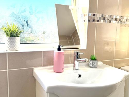 a bathroom with a pink soap dispenser on a sink at Stylish 3-Bedroom House with Garden & Free Parking's, Prime location with private garden in Kidlington