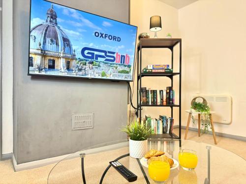 a living room with a flat screen tv on a wall at Stylish 3-Bedroom House with Garden & Free Parking's, Prime location with private garden in Kidlington