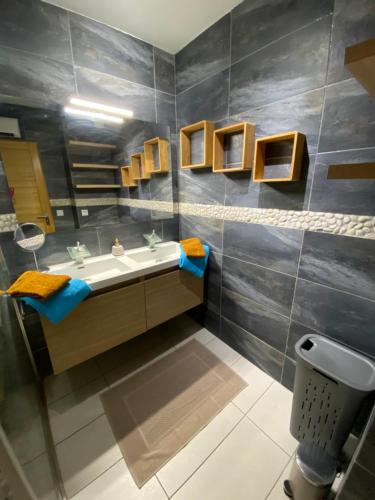 une salle de bain avec un lavabo et un miroir dans l'établissement Appartement lumineux et climatisé, face au parc privé et à 10 mins de la plage, à Cagnes-sur-Mer