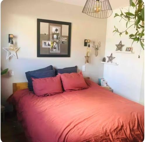 - une chambre dotée d'un lit avec des draps rouges et un miroir dans l'établissement maison moderne avec piscine, à Bains-sur-Oust