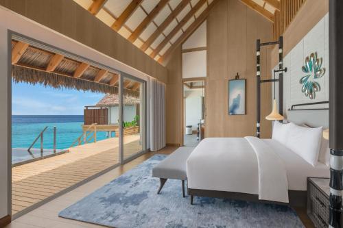 a bedroom with a bed and a view of the ocean at JW Marriott Maldives Kaafu Atoll Island Resort in Male City