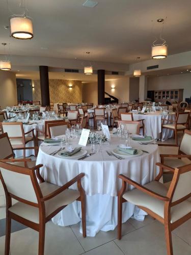 a banquet hall with white tables and chairs at Cappuccina Country Resort in San Gimignano