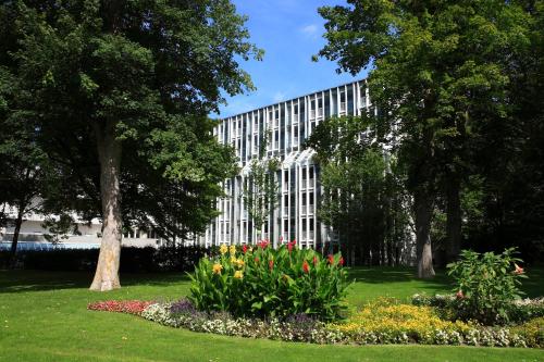 a white building with a bunch of flowers in a park at Best Western Premier Parkhotel Bad Mergentheim in Bad Mergentheim