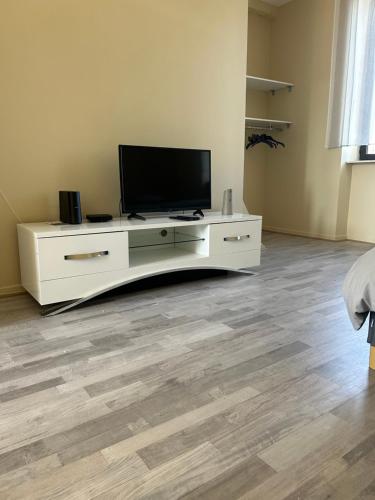 - un salon avec une télévision sur un meuble blanc dans l'établissement Studio le Saint Cosme, à Chalon-sur-Saône