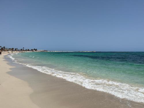 a beach with the ocean and people on it at Villa Jasmin in Midoun