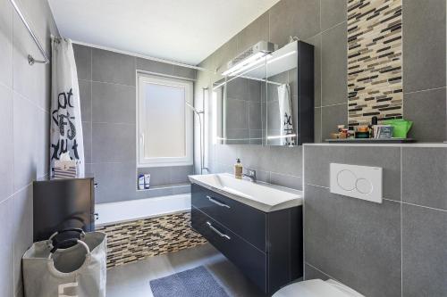 ein Badezimmer mit Waschbecken, Toilette und Spiegel in der Unterkunft le19ème Vuissens in Vuissens