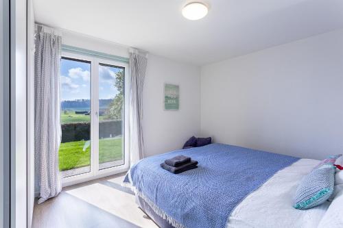 ein Schlafzimmer mit einem Bett und einem großen Fenster in der Unterkunft le19ème Vuissens in Vuissens
