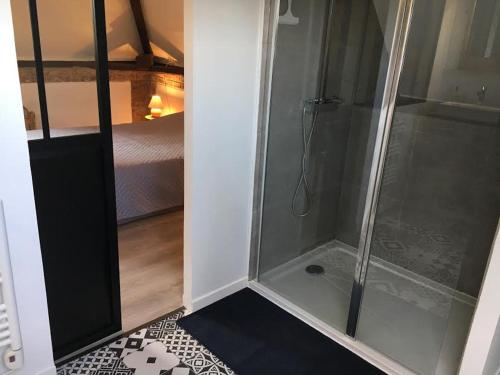 a shower with a glass door in a room at Les Noisettes Sauvages proche Etretat in Villainville