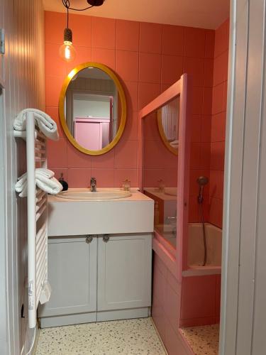 a bathroom with a sink and a tub and a mirror at La Bonbonnière Centre ville - Thermes - Netflix in Mont-Dore