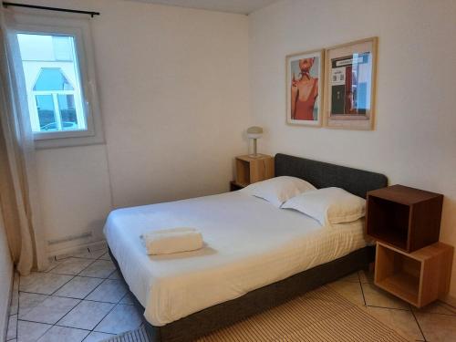 une chambre avec un lit dans une pièce avec une fenêtre dans l'établissement Évasion - Appartement 6 Prs, 2 Ch, avec Balcon, à Dijon