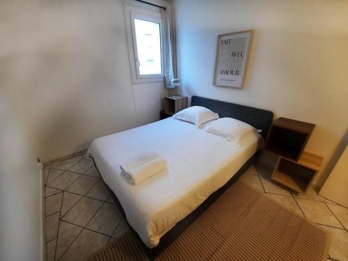 un petit lit dans une chambre avec une fenêtre dans l'établissement Évasion - Appartement 6 Prs, 2 Ch, avec Balcon, à Dijon