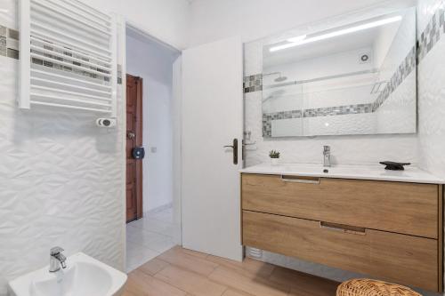 a bathroom with a sink and a shower with a mirror at 1 Bedroom Seaview Apartment in Quarteira