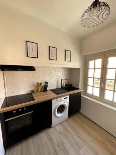 Il comprend une cuisine équipée d'un lave-linge, d'un évier et d'un lave-linge. dans l'établissement T1Bis - Coeur de Perpignan, à Perpignan