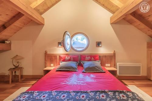 - une chambre avec un grand lit rouge et 2 oreillers dans l'établissement L'ours, à Montricher-Albanne