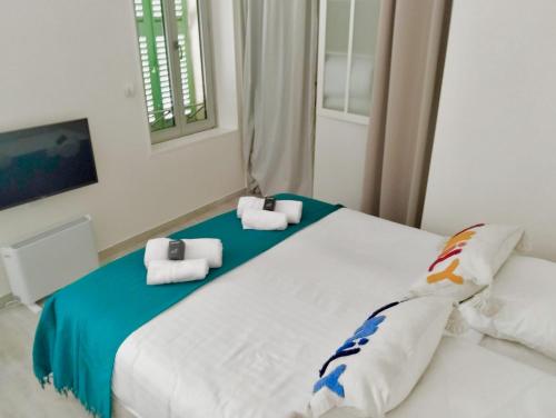 une chambre avec un grand lit blanc avec des serviettes dessus dans l'établissement PLEIN SUD - Le FAURE, à Cannes