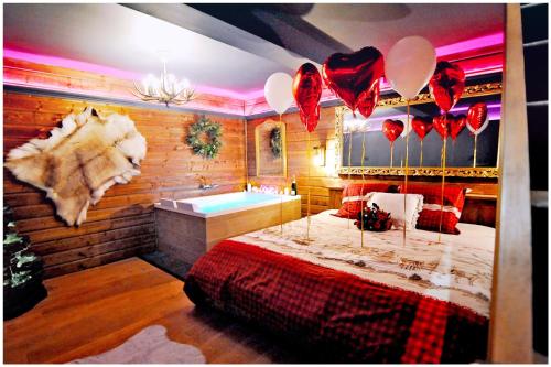 a room with a bed and a bath tub and balloons at Le Chalet romantique, SPA XXL, Écran cinéma, Lit king size, cascade d'eau in Bourgoin