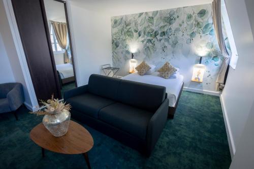 a living room with a couch and a bed at Maison Philippe Le Bon Hôtel, Restaurant & Bar le 19 in Dijon