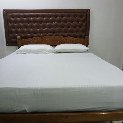 a bed with two pillows on top of it at annies inn homestay in Cochin