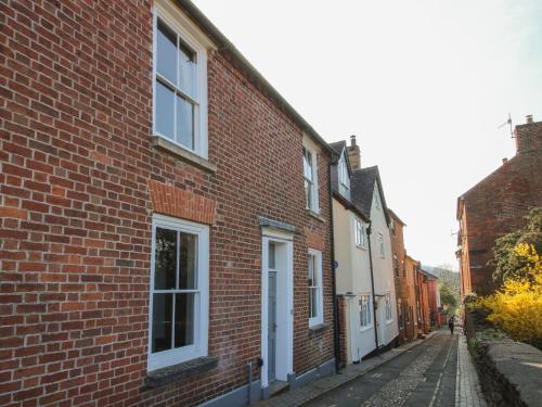 a red brick building with white windows on a street at 10 Upper Linney in Ludlow