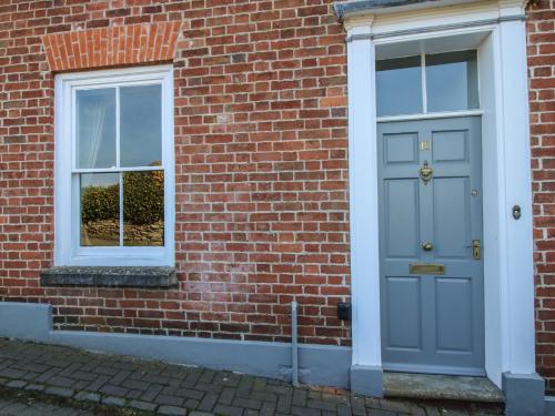 a brick building with a blue door and a window at 10 Upper Linney in Ludlow