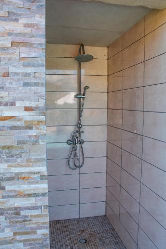 La salle de bains est pourvue d'une douche et d'un mur en briques. dans l'établissement Casa Cavu di Santa Lucia, à Sainte-Lucie de Porto-Vecchio