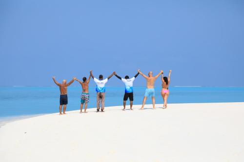 a group of people standing on the beach at Blue Coral Vashafaru Maldives in Vashafaru