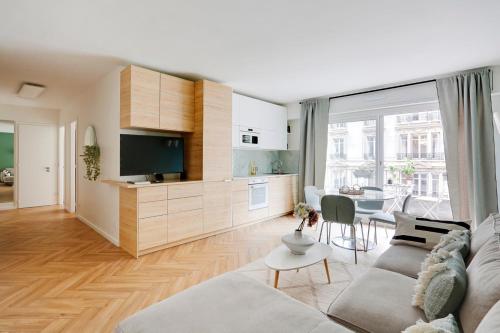 un salon avec un canapé, une télévision et une table dans l'établissement Charmant 3 pièces contemporain avec balcon ensoleillé, à Paris