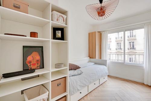 - une chambre avec des étagères blanches et un lit dans l'établissement Charmant 3 pièces contemporain avec balcon ensoleillé, à Paris