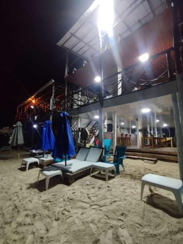 a group of chairs and tables on the beach at night at HOSTAL LAMAR BARU dónde Gertrudis in Playa Blanca