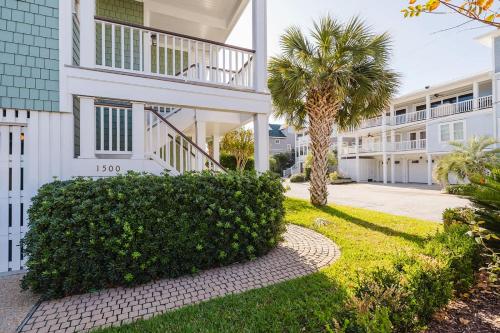 een huis met een palmboom en een loopbrug bij 1500 Lumina in Wrightsville Beach