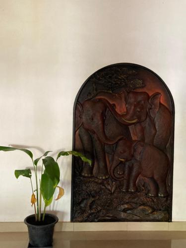 un relief en bois d'un éléphant avec deux bébés dans l'établissement Costa's Villa, Tropical Oasis, Sigiriya Room, à Kepungoda