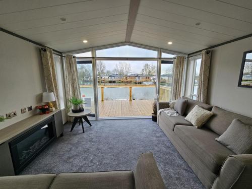 a living room with a couch and a fireplace at Bluebird lodge - Brickyard Lakes in Amotherby
