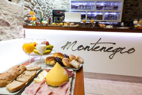 a plate of food with cheese bread and meats at Hotel Montenegro Compostela in Santiago de Compostela