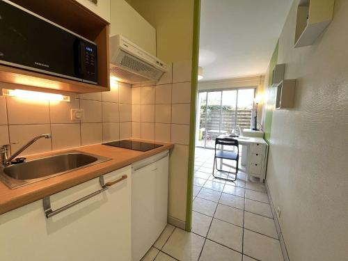 une cuisine avec un évier et un micro-ondes dans l'établissement STUDIO La Rochelle - LR930-001, à La Rochelle