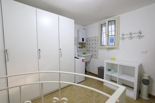 een witte badkamer met een glazen achterdeur bij Casa Indaterr in Mola di Bari