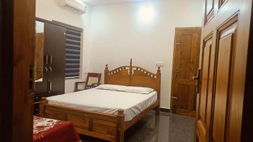 a bedroom with a bed with a wooden frame at greenview homestay Mayyil in Parassinikadavu