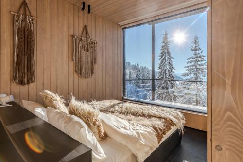 a bedroom with a bed and a large window at Висота890 in Volosyanka