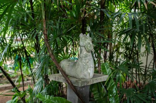 a statue of a chicken sitting on a stand in front of trees at The Fern Cove Villa - Colombo in Battaramulla