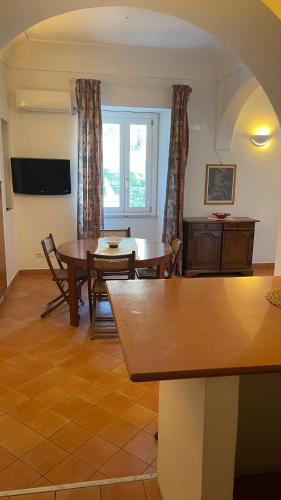 a living room with tables and chairs and a window at L'Affaccio, 4 in Atrani