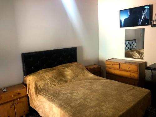 a bedroom with a bed and two dressers and a mirror at Terralta Mini Cabañas y Camping in Las Compuertas