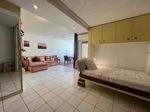 une chambre avec un lit et un salon dans l'établissement Sol-y-Days Baronnets, rez-de-chaussée avec grand jardin proche centre et plages, au Grau-du-Roi