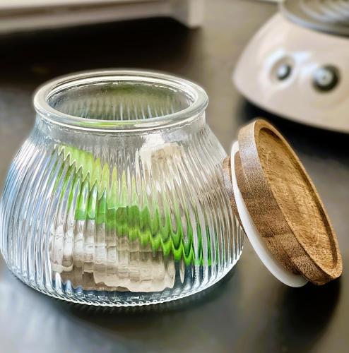 un bocal en verre rempli de soies vertes sur un comptoir dans l'établissement RM-0 - Appartement F2 au RDC à Mulhouse pour 1-3 pers, à Mulhouse