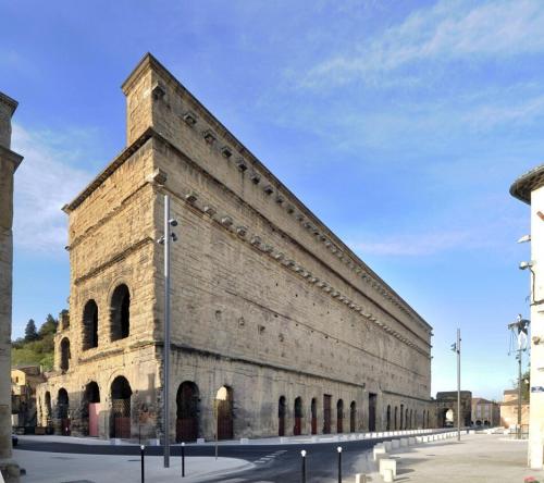 un grand bâtiment en briques avec un ciel en arrière-plan dans l'établissement Le Bien Placé tout confort, à Orange