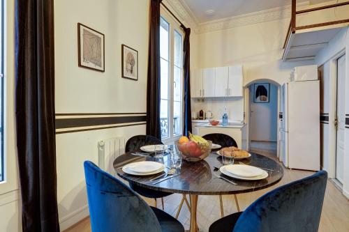 une salle à manger avec une table et des chaises et une cuisine dans l'établissement Luxueux Appartement au Coeur des Champs-elysees, à Paris