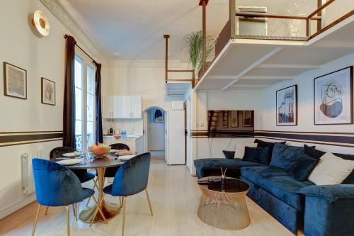 un salon avec un canapé bleu et une table dans l'établissement Luxueux Appartement au Coeur des Champs-elysees, à Paris