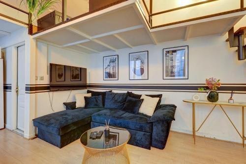 un salon avec un canapé bleu et une table dans l'établissement Luxueux Appartement au Coeur des Champs-elysees, à Paris