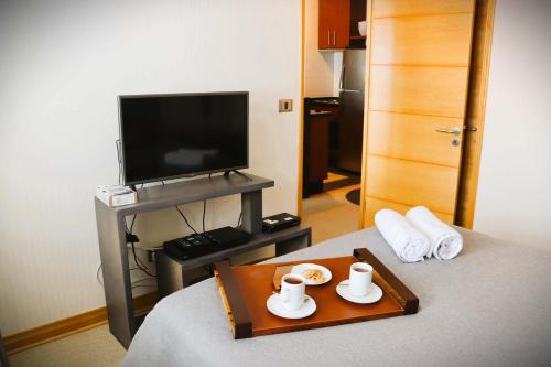 a hotel room with a bed with a tray of food at HOM I 1D1B en Valle Nevado Edif Valle Condores II VC2803 in Lo Barnechea
